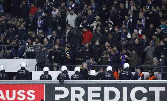 Riot police are deployed after an incident with supporters during the Europa League playoff second leg soccer match between Anderlecht and Fenerbahce at the RSC Anderlecht stadium in Brussels, Thursday, Feb. 20, 2025. (AP Photo/Omar Havana)