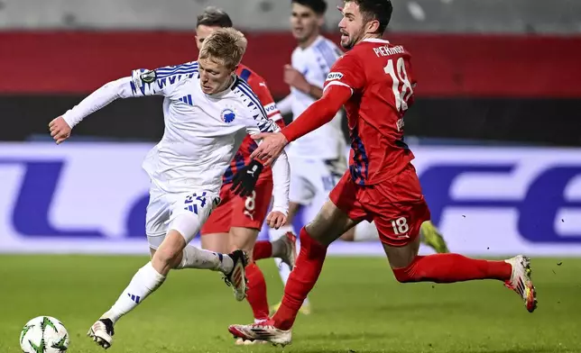 Copenhagen's Birger Meeling, left, and Heidenheim's Marvin Pieringer, right, challenge for the ball during a Conference League playoff match between FC Heidenheim 1846 and FC Copenhagen in Heidenheim, Germany, Thursday, Feb. 20, 2025. (Harry Langer/dpa via AP)