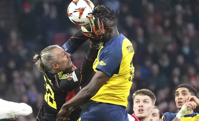 Ajax's goalkeeper Remko Pasveer, left, challenges for the ball with Union SG's Promise David during the Europa League play-off soccer match between Ajax and Union Saint-Gilloise at the Johan Cruyff ArenA in Amsterdam, Netherlands, Thursday, Feb. 20, 2025. (AP Photo/Peter Dejong)