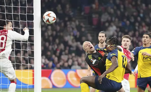 Ajax's goalkeeper Remko Pasveer, center, challenges for the ball with Union SG's Promise David during the Europa League play-off soccer match between Ajax and Union Saint-Gilloise at the Johan Cruyff ArenA in Amsterdam, Netherlands, Thursday, Feb. 20, 2025. (AP Photo/Peter Dejong)