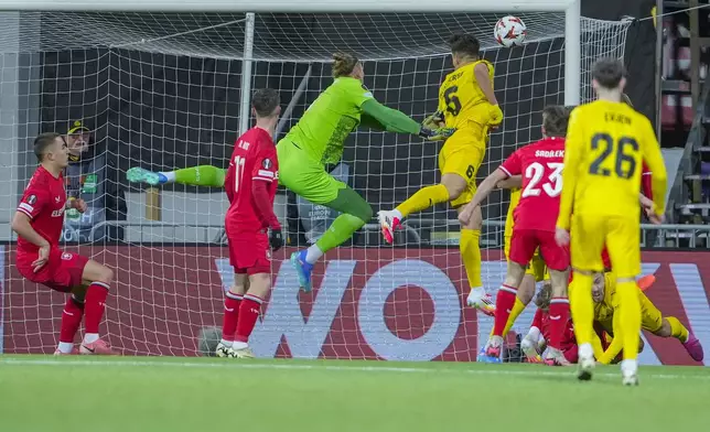 Twente's goalkeeper Lars Unnerstall, centre, and Bodø/Glimt's Jostein Gundersen, centre right, challenge for the ball during the Europa League soccer match between FK Bodø/Glimt and FC Twente in Bodo, Norway, Thursday, Feb. 20, 2025. (Fredrik Varfjell/NTB Scanpix via AP)