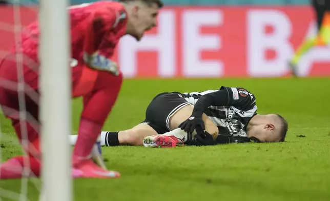 PAOK's Dimitrios Pelkas holds his leg after an injury during the Europa League playoff stage second leg soccer match between FCSB and PAOK at the National Arena stadium, Thursday, Feb. 20, 2025. (AP Photo/Andreea Alexandru)