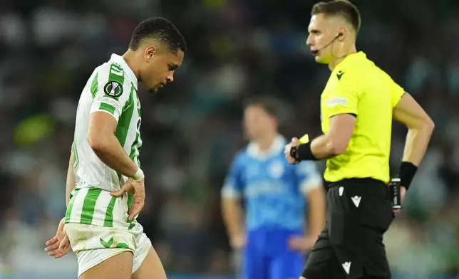 Betis' Vitor Roque walks past the referee after receiving a red card during the Conference League playoff second leg soccer match between Betis and Gent at the Benito Villamarin stadium in Seville, Spain, Thursday Feb. 20, 2025. (AP Photo/Jose Breton)