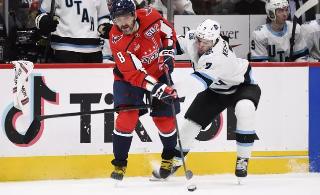 Washington Capitals left wing Alex Ovechkin (8) passes the puck against Utah Hockey Club defenseman Michael Kesselring (7) during the second period of an NHL hockey game, Sunday, Feb. 9, 2025, in Washington. (AP Photo/Nick Wass)