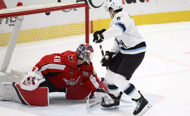 Utah Hockey Club center Nick Schmaltz (8) scores during the shootout of an NHL hockey game against Washington Capitals goaltender Logan Thompson (48), Sunday, Feb. 9, 2025, in Washington. (AP Photo/Nick Wass)