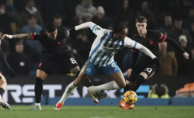 Brighton's Joao Pedro in action in front of Chelsea's Enzo Fernandez, left, and Cole Palmer during the English Premier League soccer match between Brighton and Chelsea in Brighton, England, Friday, Feb. 14, 2025. (AP Photo/Dave Shopland)