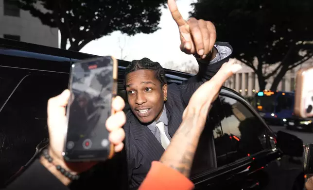 A$AP Rocky gestures out of the window of a vehicle while leaving court after he was found not guilty in his trial Tuesday, Feb. 18, 2025, in Los Angeles. (AP Photo/Damian Dovarganes)