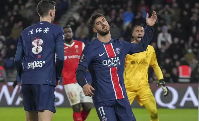 PSG's Marco Asensio, centre, reacts after missing a chance during the French League One soccer match between Paris Saint-Germain and Reims at Parc des Princes stadium in Paris, Saturday, Jan. 25, 2025. (AP Photo/Michel Euler)