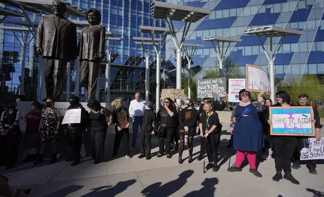Protestors hold signs during a rally for a nationwide economic blackout Wednesday, Feb. 26, 2025, in Las Vegas. (AP Photo/John Locher)