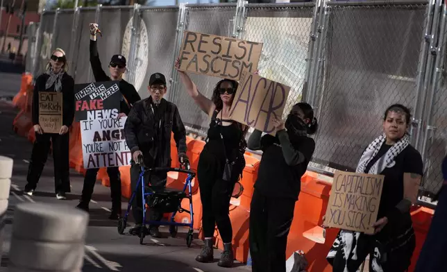 Protestors hold signs during a rally for a nationwide economic blackout Wednesday, Feb. 26, 2025, in Las Vegas. (AP Photo/John Locher)