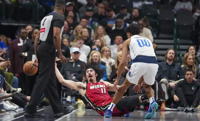 Miami Heat guard Jaime Jaquez Jr. (11) tries to keep the ball in bounds while being challenged by Dallas Mavericks guard Max Christie (00) during the first half of an NBA basketball game Thursday, Feb. 13, 2025, in Dallas. (AP Photo/Julio Cortez)