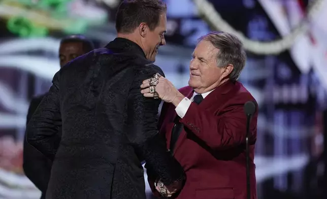 Coach Bill Belichick hugs and presents the AP Coach of the year award to Minnesota Vikings coach Kevin O'Connell during the NFL Honors award show ahead of the Super Bowl 59 football game, Thursday, Feb. 6, 2025, in New Orleans. (AP Photo/David J. Phillip)