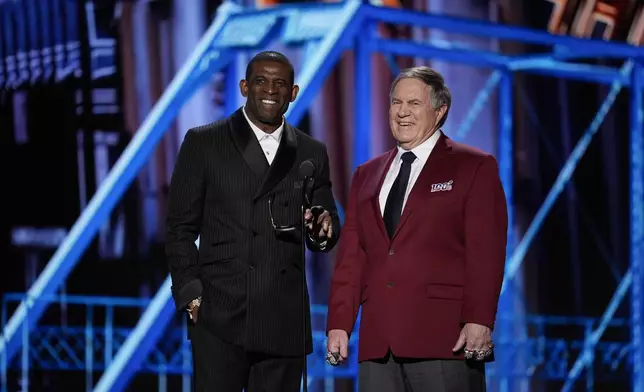 Coaches Deion Sanders, left, and Bill Belichick, right present the Coach of the year award during the NFL Honors award show ahead of the Super Bowl 59 football game, Thursday, Feb. 6, 2025, in New Orleans. (AP Photo/David J. Phillip)