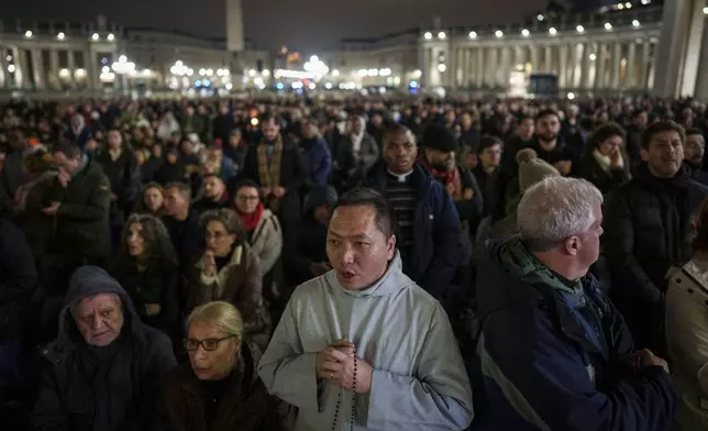 Faithful pray during a nightly rosary in St. Peter's Square at The Vatican for Pope Francis' recovery, Monday, Feb. 24, 2025. (AP Photo/Bernat Armangue)