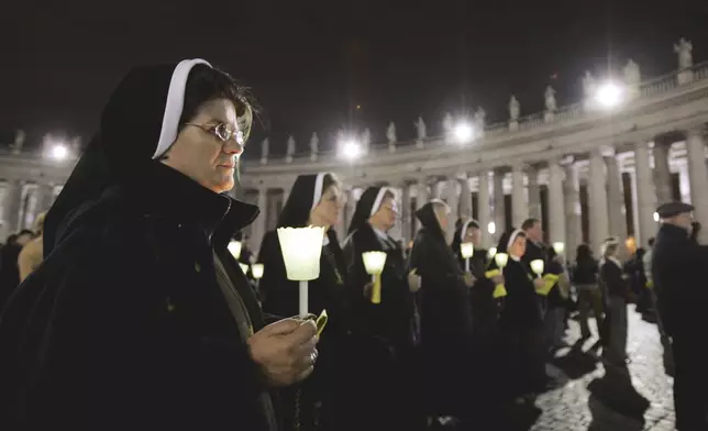 FILE - Nuns hold candles during a rosary vigil prayer in St. Peter's Square at The Vatican for Pope John Paul II's health Friday, April 1, 2005 (AP Photo / Luca Bruno, File )