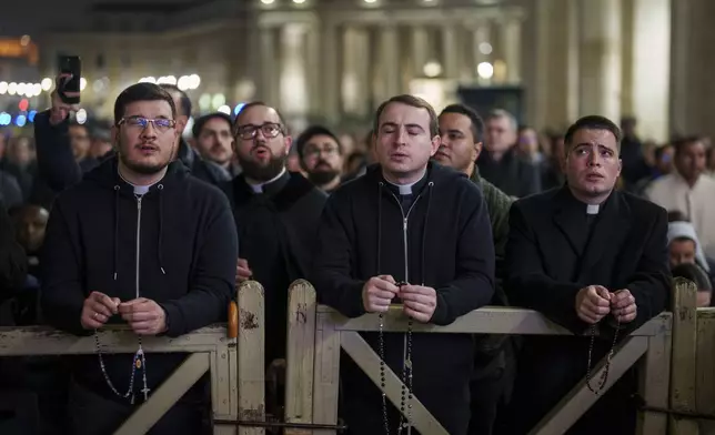Catholic priests pray the rosary in St. Peter's Square at The Vatican for the recovery of Pope Francis, Monday, Feb. 24, 2025. (AP Photo/Bernat Armangue)