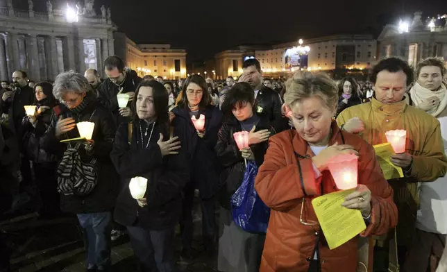 FILE - Faithful make the sign of the cross during a rosary vigil prayer for Pope John Paul II's health in St. Peter's Square at The Vatican, Friday, April 1, 2005. (AP Photo/Luca Bruno, file)