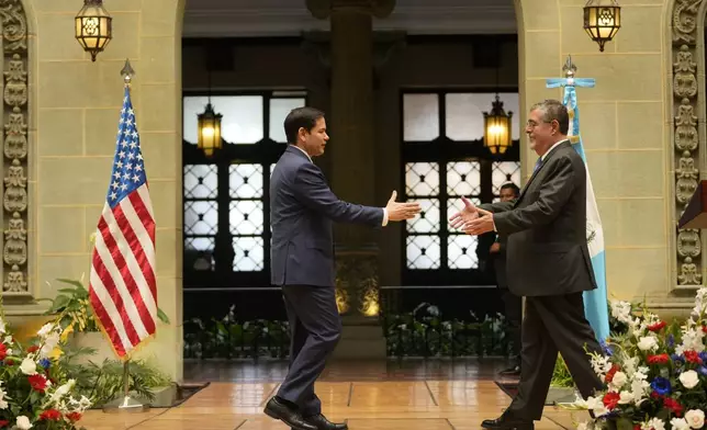 U.S. Secretary of State Marco Rubio, left, and Guatemalan President Bernardo Arevalo reach out to shake hands at the end of their joint news conference at the National Palace in Guatemala City, Wednesday, Feb. 5, 2025. (AP Photo/Mark Schiefelbein, Pool)