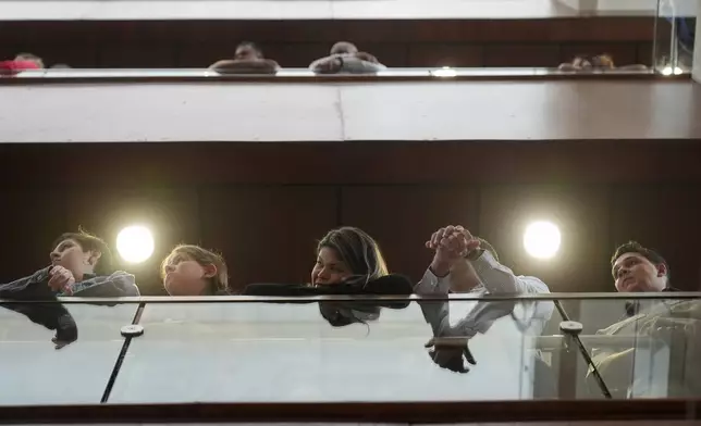 People watch Secretary of State Marco Rubio during a meet-and-greet with employees and family at the United States Embassy in Panama City Panama City, Sunday, Feb. 2, 2025. (AP Photo/Mark Schiefelbein, Pool)