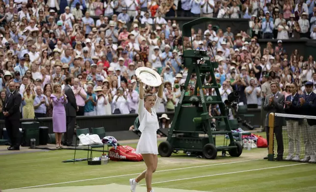 FILE - Romania's Simona Halep holds her trophy after defeating United States' Serena Williams in the women's singles final match on day twelve of the Wimbledon Tennis Championships in London, July 13, 2019. (AP Photo/Tim Ireland, file)