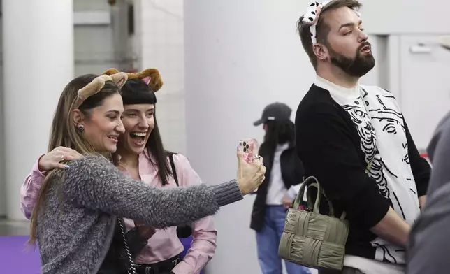 Hadley Cooper, left, and Amanda Gabriele take a selfie while watching the Masters Agility Championship Finals during the 149th Westminster Kennel Club Dog show, Saturday, Feb. 8, 2025, in New York. (AP Photo/Heather Khalifa)