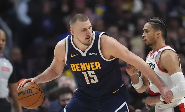 Denver Nuggets center Nikola Jokic, left, drives to the basket as Portland Trail Blazers forward Toumani Camara defends in the second half of an NBA basketball game Wednesday, Feb. 12, 2025, in Denver. (AP Photo/David Zalubowski)