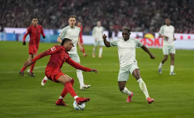 Bayern's Michael Olise, left, fights for the ball with Bremen's Derrick Koehn during the German Bundesliga soccer match between Bayern Munich and Werder Bremen at the Allianz Arena in Munich, Germany, Friday, Feb. 7, 2025. (AP Photo/Matthias Schrader)