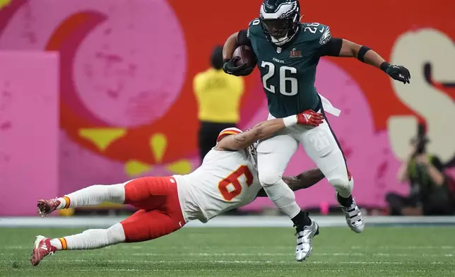 Philadelphia Eagles running back Saquon Barkley (26) tries to elude the tackle of Kansas City Chiefs safety Bryan Cook (6) during the first half of the NFL Super Bowl 59 football game, Sunday, Feb. 9, 2025, in New Orleans. (AP Photo/Frank Franklin II)