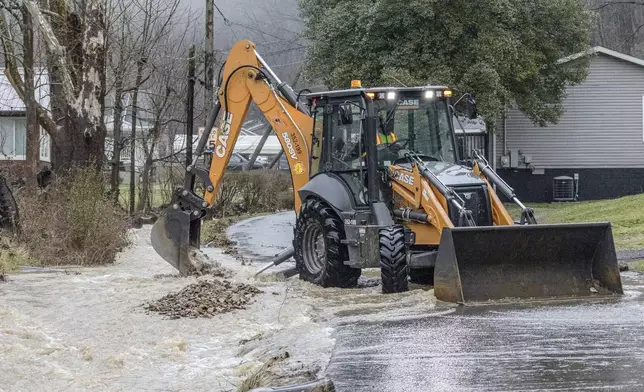 A state road crew cleared debris from a creek along Big Bottom Hollow Road in Campbells Creek, just outside of Charleston, W.Va.,, after flood waters came across the roadway and entered the nearby Mary Ingles Elementary School on Thursday Feb. 6, 2025. (Sean McCallister