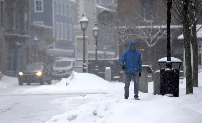 A person walks through the snow during a storm in Portsmouth, N.H., Thursday, Feb. 6, 2025. (AP Photo/Caleb Jones)