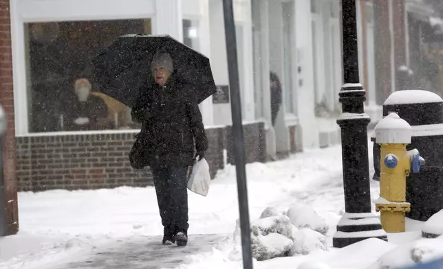 A person walks through the snow during a storm in Portsmouth, N.H., Thursday, Feb. 6, 2025. (AP Photo/Caleb Jones)
