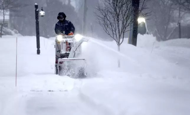 A crew clears snow during a storm in Portsmouth, N.H., Thursday, Feb. 6, 2025. (AP Photo/Caleb Jones)