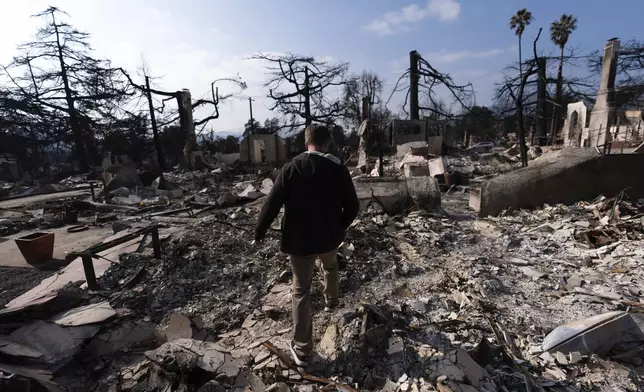 FILE - Chris Wilson walks through the remains of his home, consumed by the Eaton Fire, in Altadena, Calif., Thursday, Jan. 30, 2025. (AP Photo/Jae C. Hong, File )