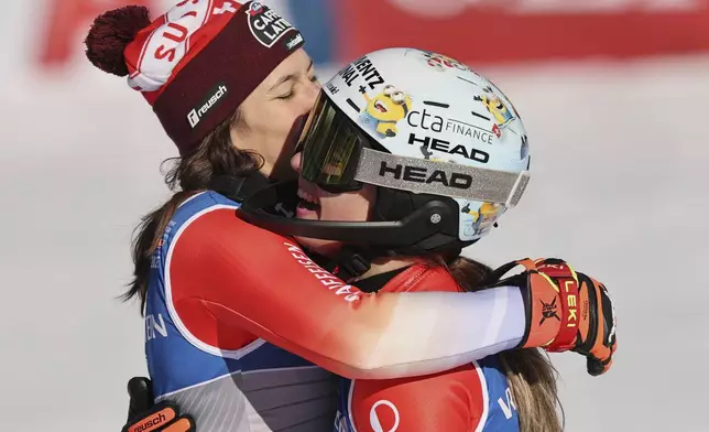Switzerland's Wendy Holdener, left, hugs Switzerland's Camille Rast after winning the silver (Holdener) and gold medal a women's slalom, at the Alpine Ski World Championships, in Saalbach-Hinterglemm, Austria, Saturday, Feb. 15, 2025. (AP Photo/Marco Trovati)