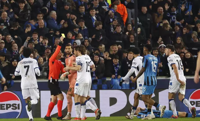 The referee shows the yellow card to the Atalanta's Isak Hien during the Champions League playoff first leg soccer match between Club Brugge and Atalanta at the Jan Breydel Stadium in Bruges, Belgium, Wednesday, Feb. 12, 2025. (AP Photo/Geert Vanden Wijngaert)