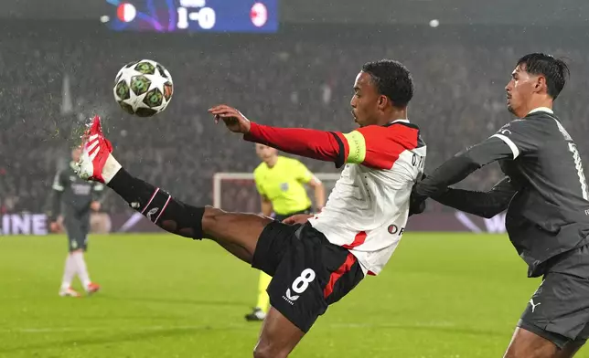 Feyenoord's Quinten Timber kicks the ball next to AC Milan's Tijjani Reijnders during the Champions League playoff first leg soccer match between Feyenoord and AC Milan, at the De Kuip stadium, in Rotterdam, Netherlands, Wednesday, Feb. 12, 2025. (AP Photo/Peter Dejong)