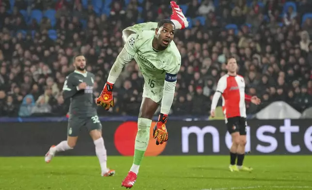 AC Milan's goalkeeper Mike Maignan dives to save a shot during the Champions League playoff first leg soccer match between Feyenoord and AC Milan, at the De Kuip stadium, in Rotterdam, Netherlands, Wednesday, Feb. 12, 2025. (AP Photo/Peter Dejong)