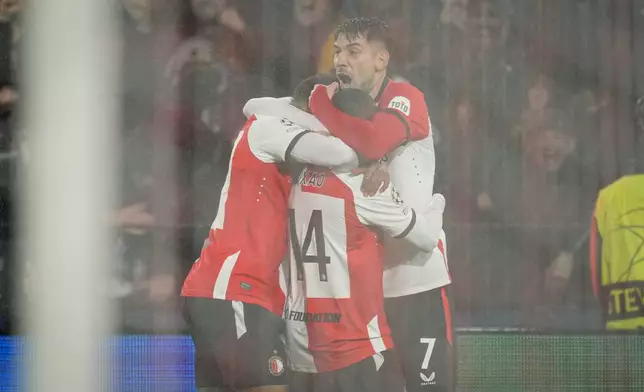Feyenoord's Igor Paixao, center, celebrates after scoring his side's first goal during the Champions League playoff first leg soccer match between Feyenoord and AC Milan, at the De Kuip stadium, in Rotterdam, Netherlands, Wednesday, Feb. 12, 2025. (AP Photo/Peter Dejong)