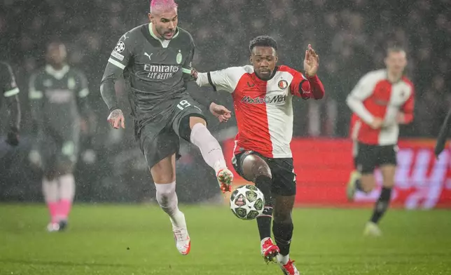 Feyenoord's Antoni Milambo, right, challenges for the ball with AC Milan's Theo Hernandez during the Champions League playoff first leg soccer match between Feyenoord and AC Milan, at the De Kuip stadium, in Rotterdam, Netherlands, Wednesday, Feb. 12, 2025. (AP Photo/Peter Dejong)