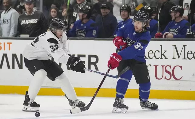 Team Blue player actor Taylor Kitsch passes the puck against Team White player actor and singer Ross Lynch during the Skate for LA Strong celebrity hockey game, Sunday, Feb. 23, 2025, in Los Angeles. (AP Photo/Eric Thayer)
