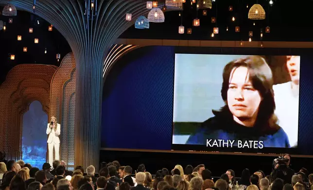 Host Kristen Bell, left, speaks while an imagine of a young Kathy Bates is on the screen during the 31st annual Screen Actors Guild Awards on Sunday, Feb. 23, 2025, at the Shrine Auditorium in Los Angeles. (AP Photo/Chris Pizzello)