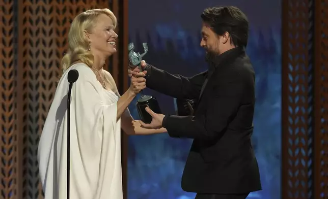 Pamela Anderson, left, presents the award for outstanding performance by a male actor in a supporting role to Kieran Culkin for "A Real Pain" during the 31st annual Screen Actors Guild Awards on Sunday, Feb. 23, 2025, at the Shrine Auditorium in Los Angeles. (AP Photo/Chris Pizzello)