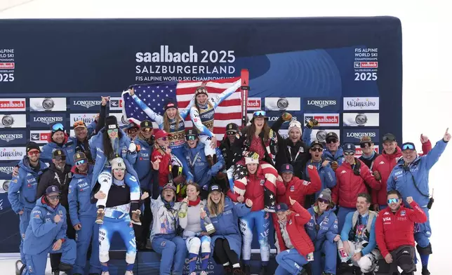 United States' Mikaela Shiffrin, top left, and United States' Breezy Johnson, top right, celebrate with the team after winning the gold medal in a women's team combined event, at the Alpine Ski World Championships, in Saalbach-Hinterglemm, Austria, Tuesday, Feb. 11, 2025. (AP Photo/Giovanni Auletta)