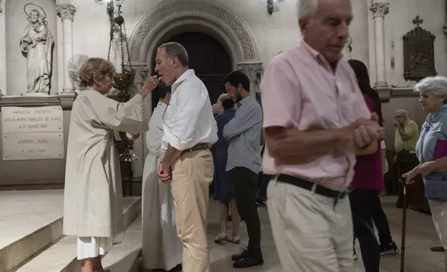 Believers take communion during a Mass for Pope Francis' health in Buenos Aires, Argentina, Wednesday, Feb. 19, 2025. (AP Photo/Rodrigo Abd)
