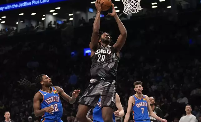Brooklyn Nets' Day'Ron Sharpe (20) drives past Oklahoma City Thunder's Cason Wallace (22) and Chet Holmgren (7) during the first half of an NBA basketball game Wednesday, Feb. 26, 2025, in New York. (AP Photo/Frank Franklin II)