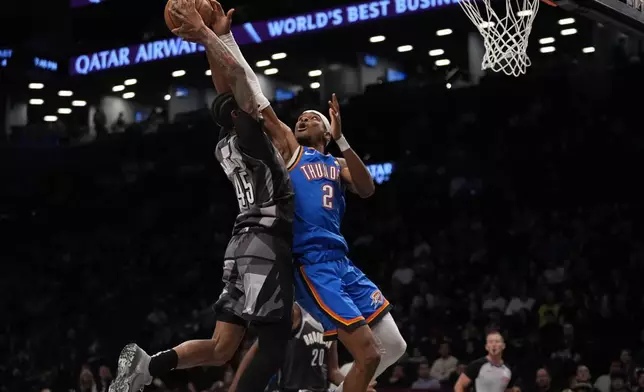 Oklahoma City Thunder's Shai Gilgeous-Alexander (2) defends a shot by Brooklyn Nets' Keon Johnson (45) during the first half of an NBA basketball game Wednesday, Feb. 26, 2025, in New York. (AP Photo/Frank Franklin II)