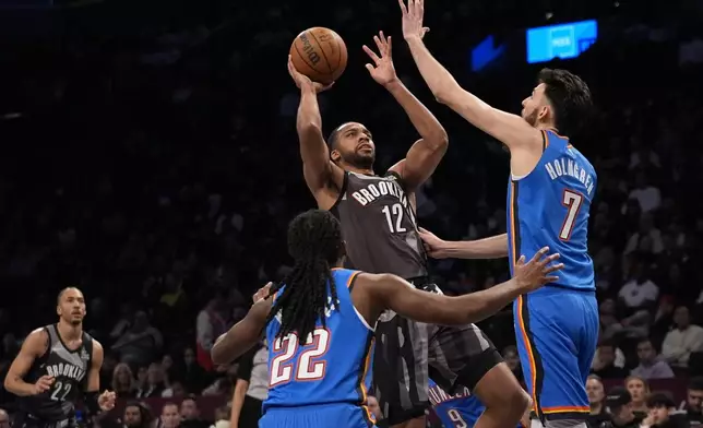 Brooklyn Nets' Tosan Evbuomwan (12) shoots over Oklahoma City Thunder's Chet Holmgren (7) and Cason Wallace (22) during the first half of an NBA basketball game Wednesday, Feb. 26, 2025, in New York. (AP Photo/Frank Franklin II)