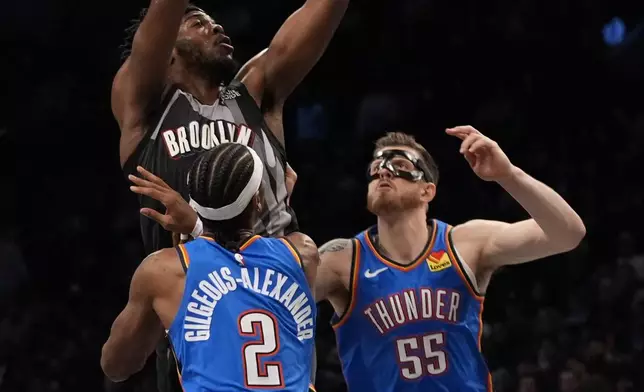 Brooklyn Nets' Day'Ron Sharpe shoots over Oklahoma City Thunder's Shai Gilgeous-Alexander (2) and Isaiah Hartenstein (55) during the first half of an NBA basketball game Wednesday, Feb. 26, 2025, in New York. (AP Photo/Frank Franklin II)