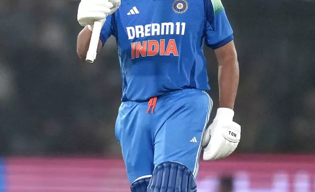 India's captain Rohit Sharma raises his bat as he celebrates after scoring a century during the second one day international cricket match between India and England in Cuttack, India, Sunday, Feb. 9, 2025. (AP Photo/Rafiq Maqbool)