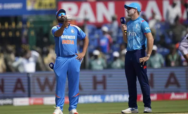 India's captain Rohit Sharma, left, flips the coins for toss as England's captain Jos Buttler watches before the start of the second one day international cricket match between India and England in Cuttack, India, Sunday, Feb. 9, 2025. (AP Photo/Rafiq Maqbool)